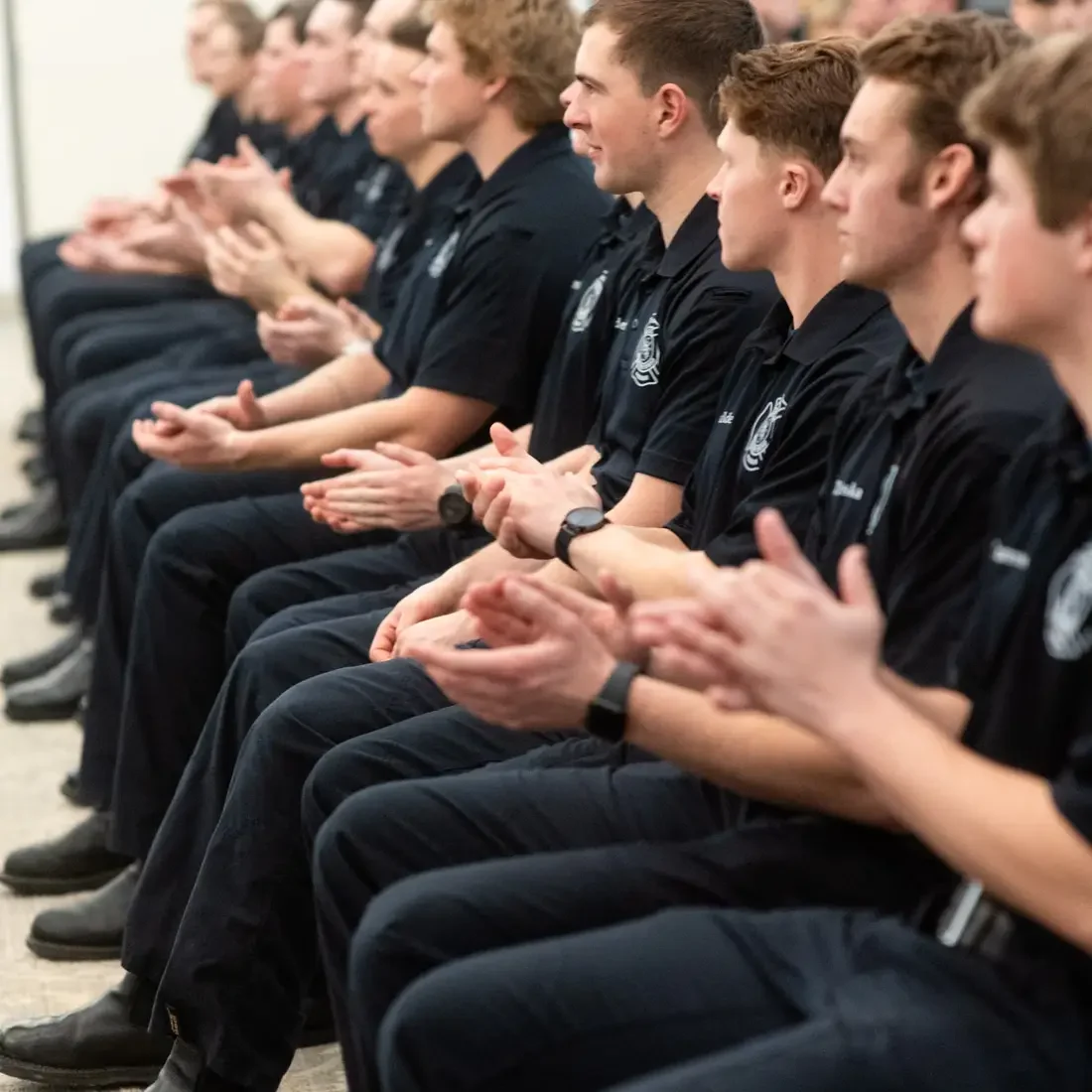 Graduates applause during a ceremony.