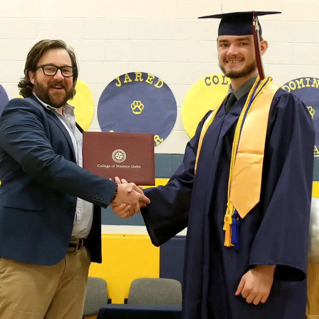 CWI Director of Dual Credit, Stephen Crumrine, presents Idaho City High School senior, Jason Carignan with his associate degree.