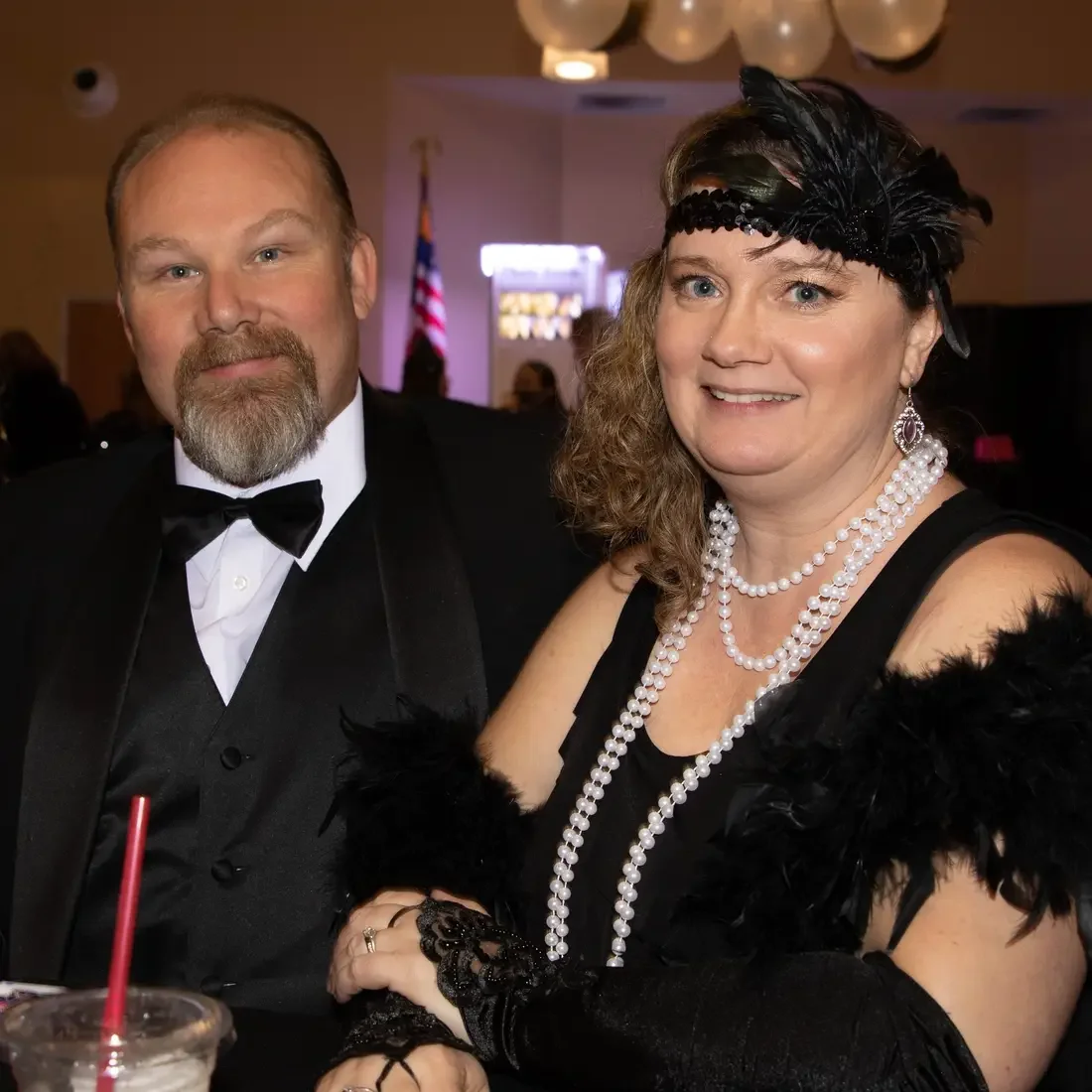 Man and woman in 1920s costumes sitting at a table