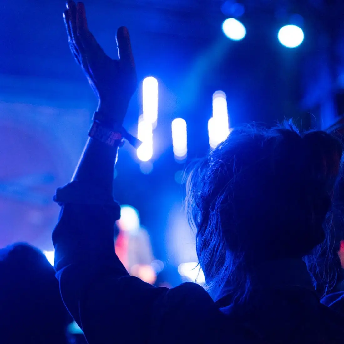 A concert goer dances during a live music performance.