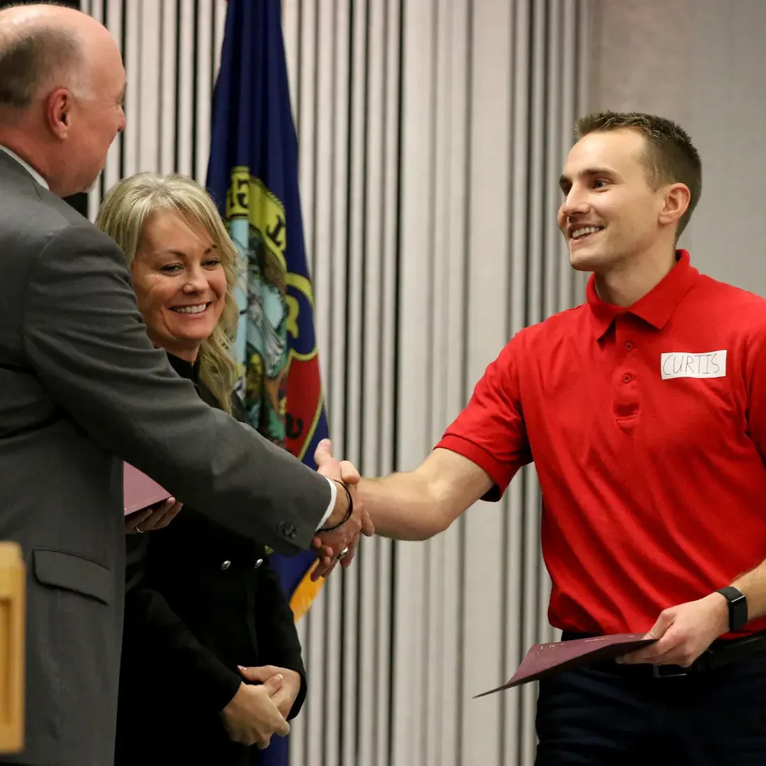 Fire Service Technology student Austin Curtis greets Kevin Platts during graduation