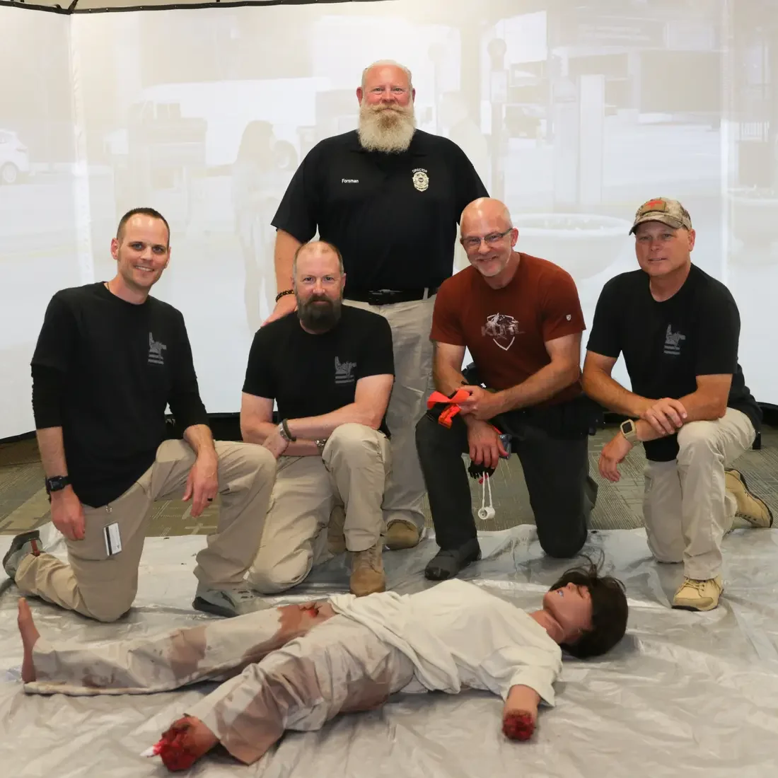 Medical tactical training posing with bleeding mannequin