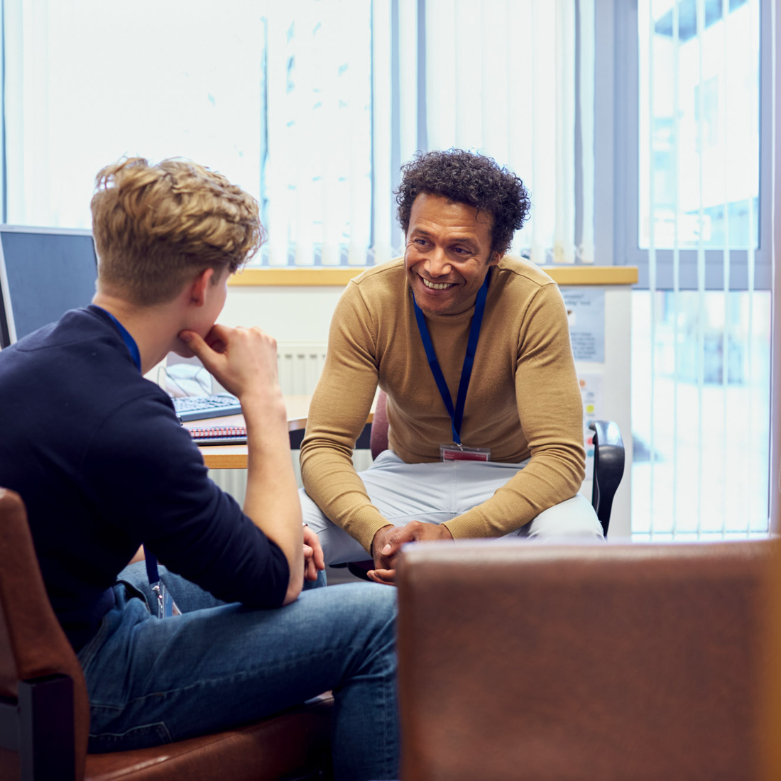 A college counselor listens to a student in his office.