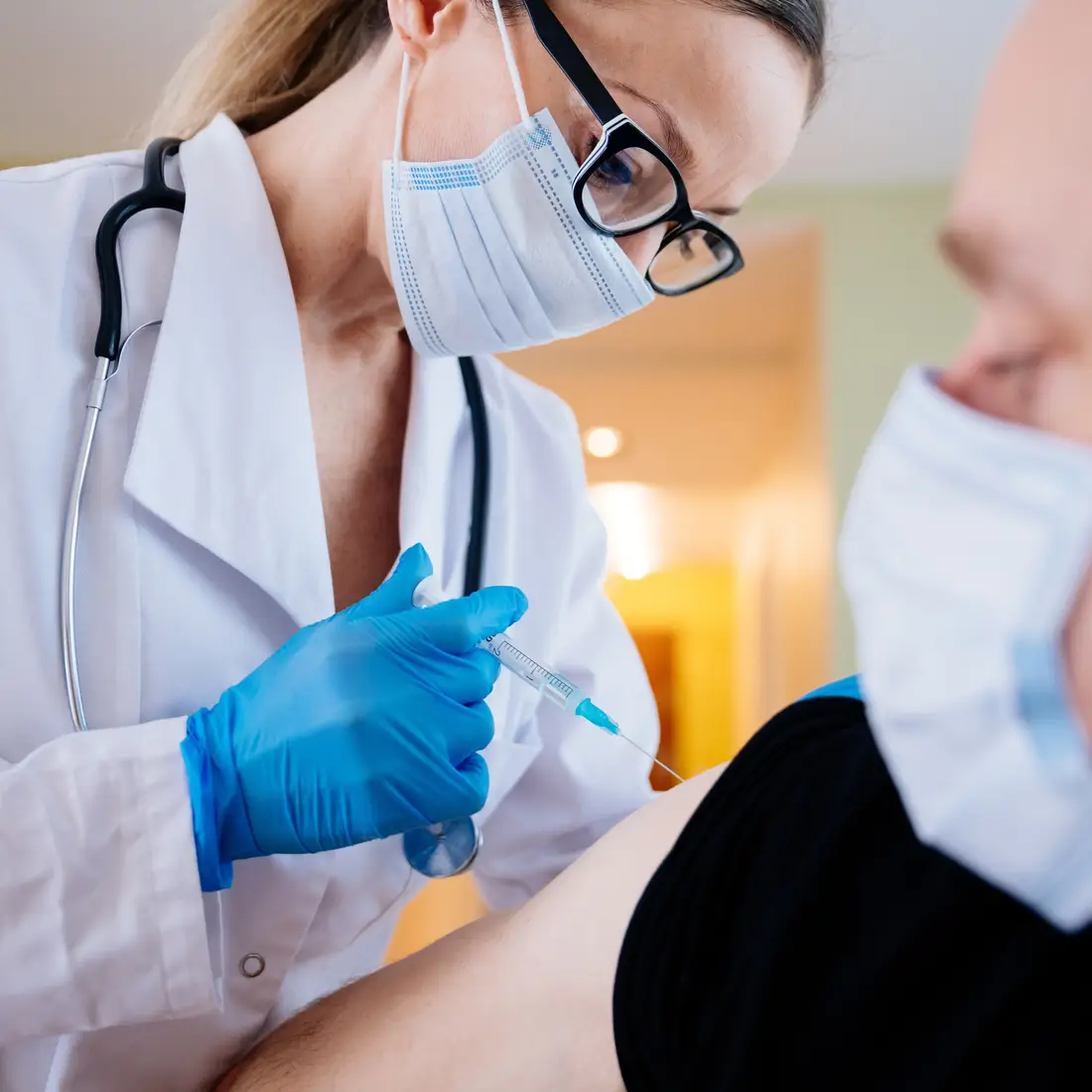 doctor injecting vaccine into patient arm