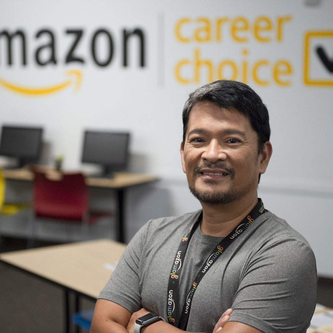 Individual standing a classroom with Amazon logo on the wall