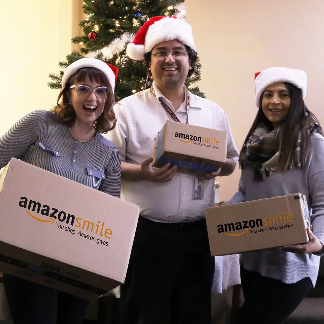 Students with amazon smile boxes in front of Christmas tree