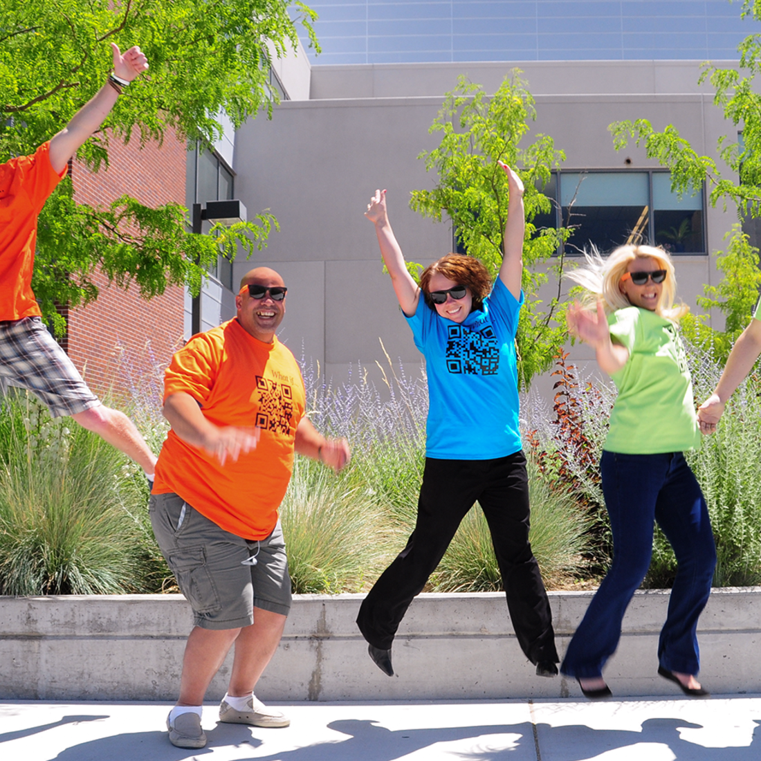 Happy students jumping in celebration outside a CWI building.