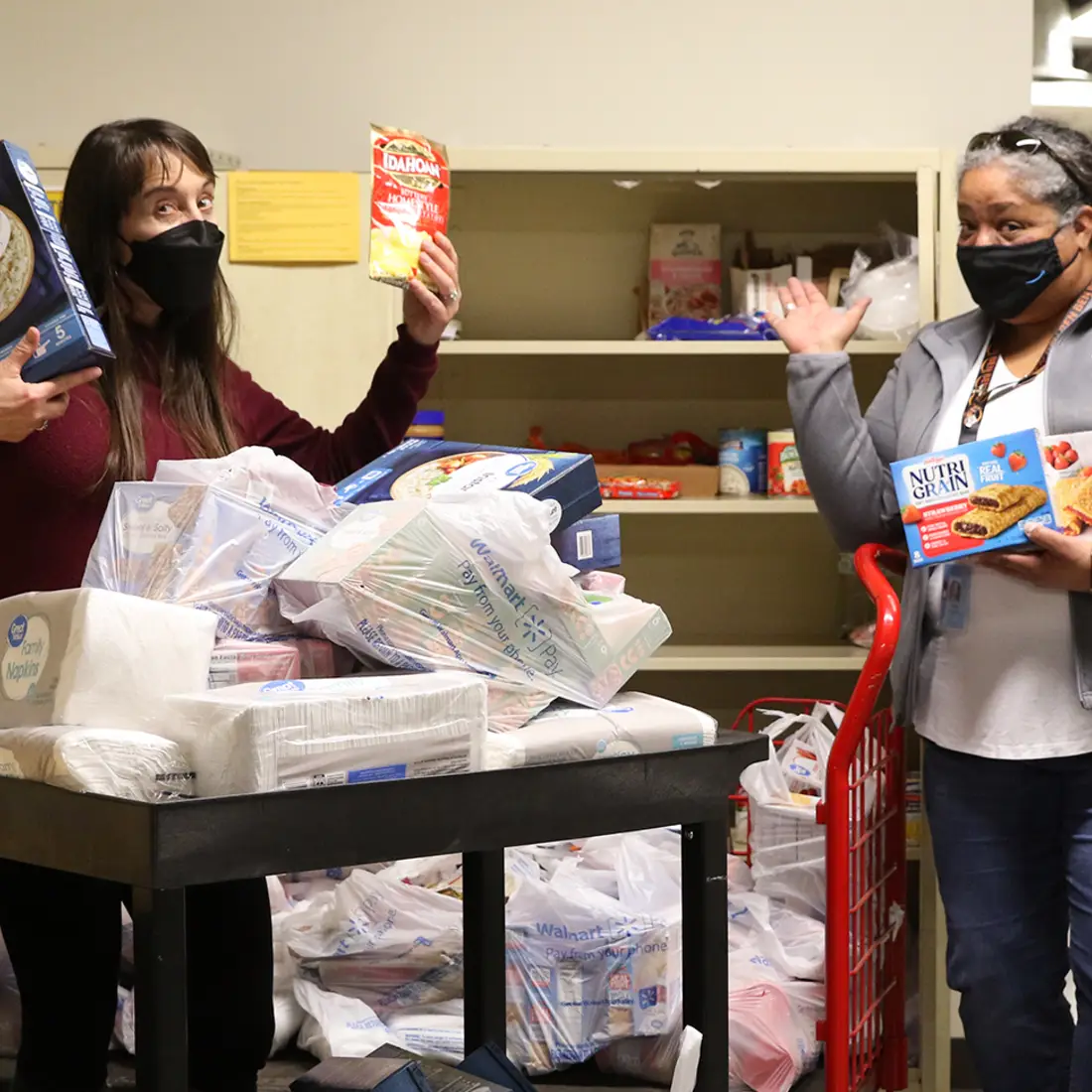 CWI's Christy Babcock and Teresa Wiegand from Amazon posing outside campus food pantry with Amazon donation