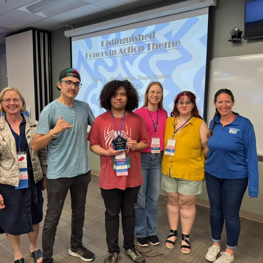 Students and faculty standing in front of projection screen