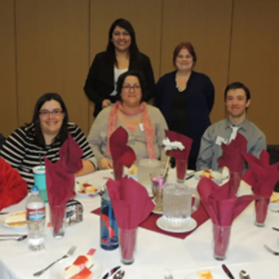 Students sitting at table while receiving awards