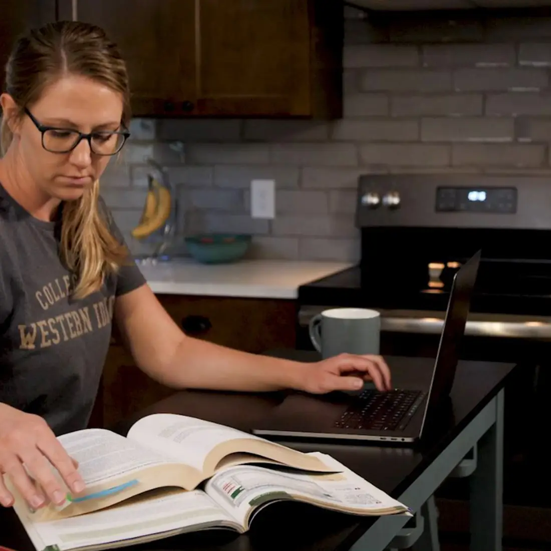 CWI student studying with books and a laptop at home
