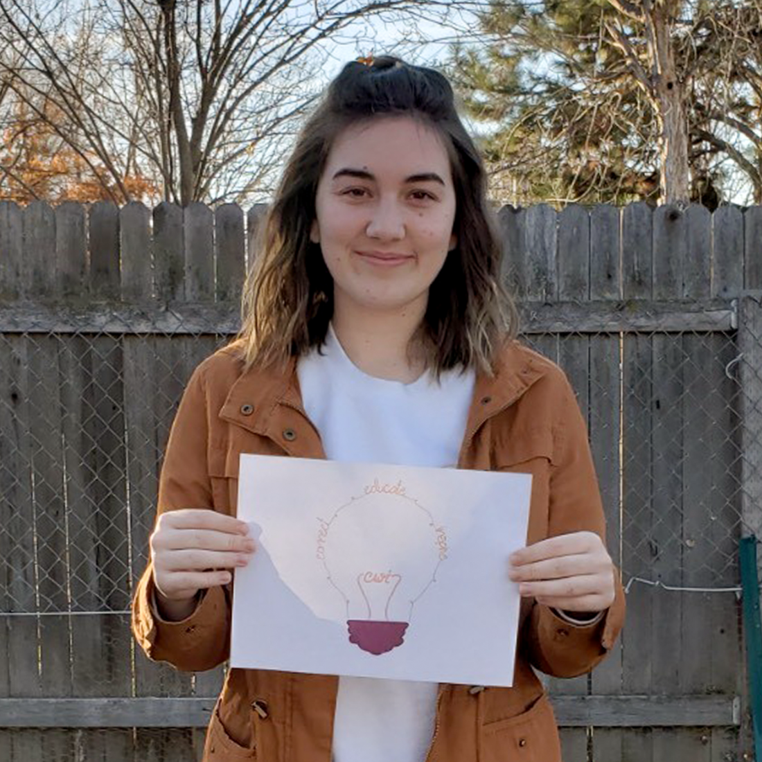 Malary Snow holding a print out of her logo design