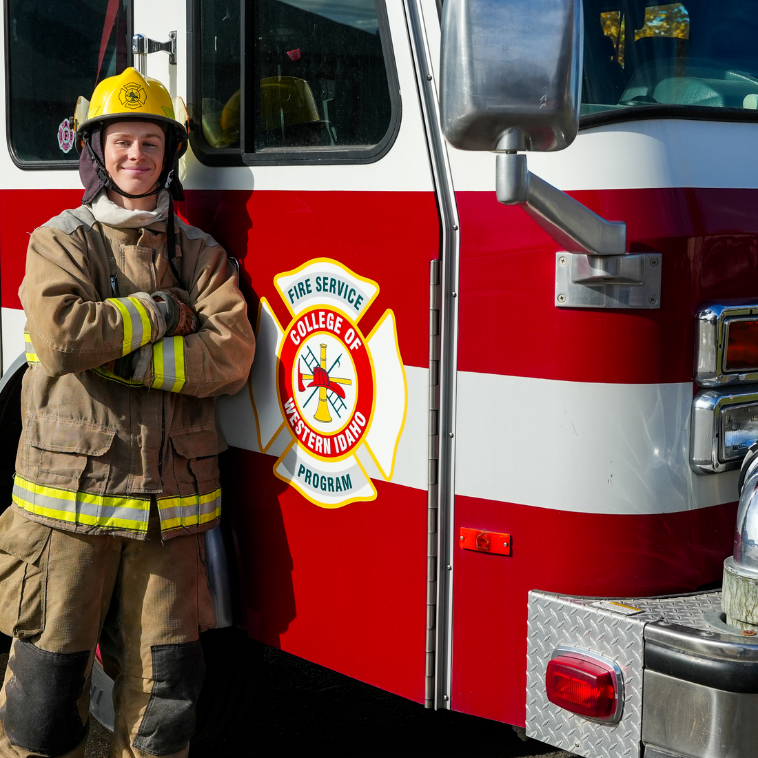 Firefighting student standing next to fire truck