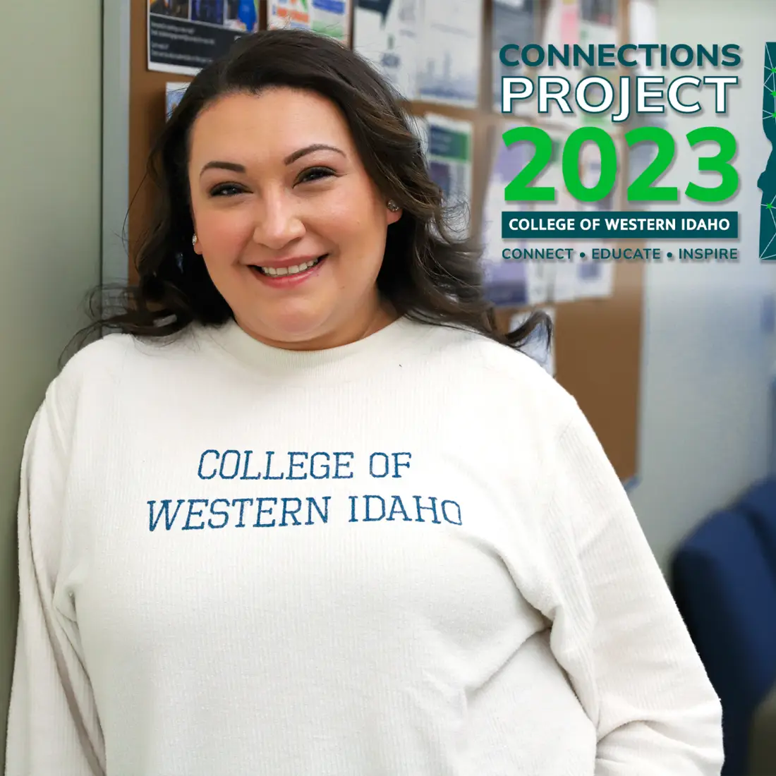 Eiko Pruett leaning against a wall wearing a white CWI sweater