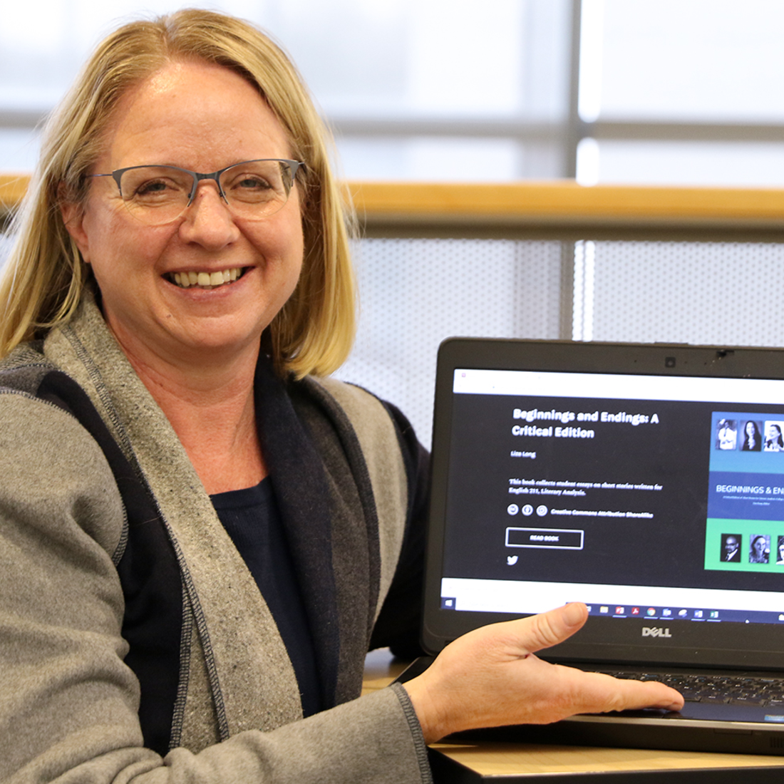 Liza Long showing off her students' online book, Beginnings and Endings, on her laptop