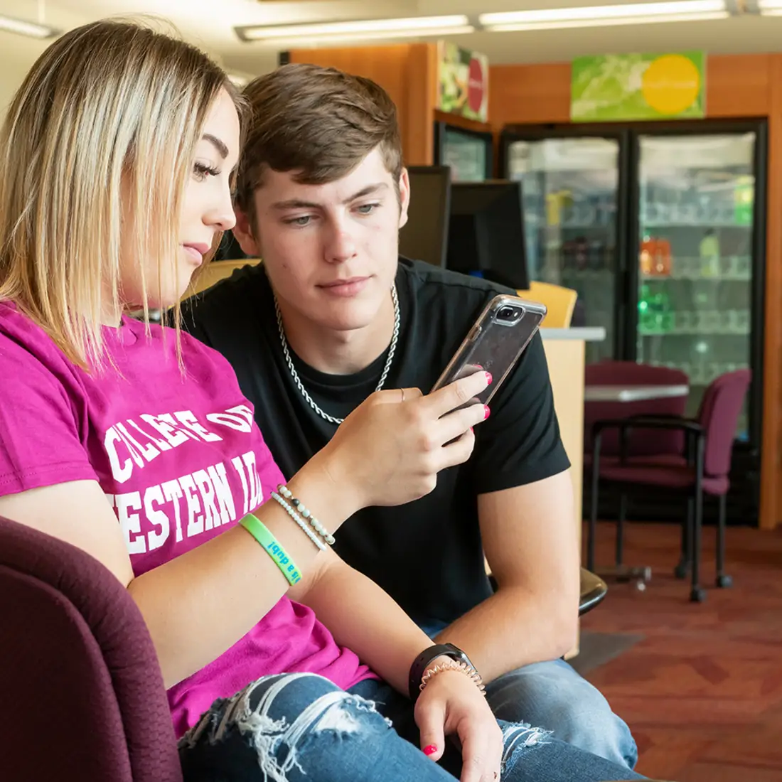 Two students looking at a cell phone 