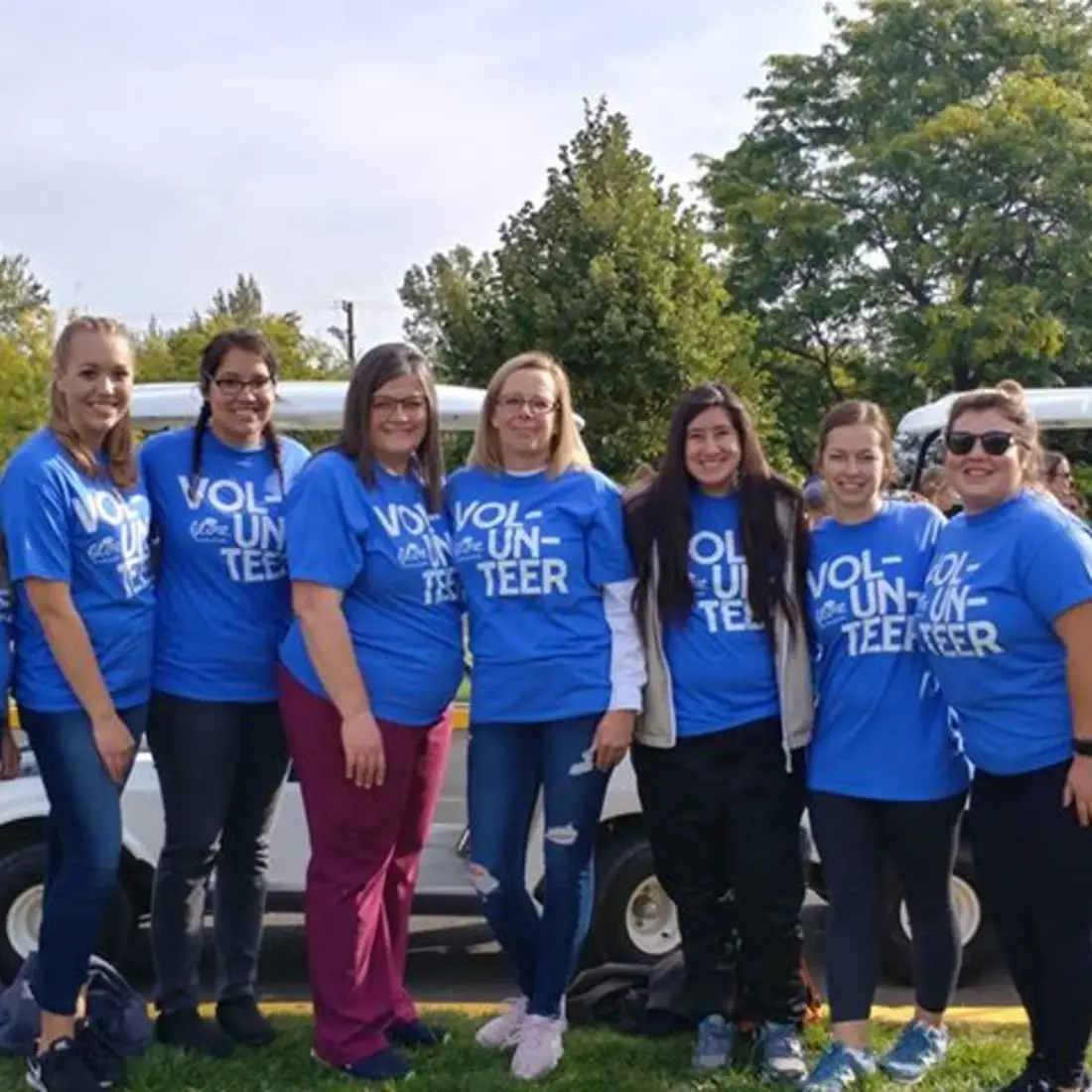 Members of the Student Nurses Association outside posing for a photo wearing volunteer shirts. 