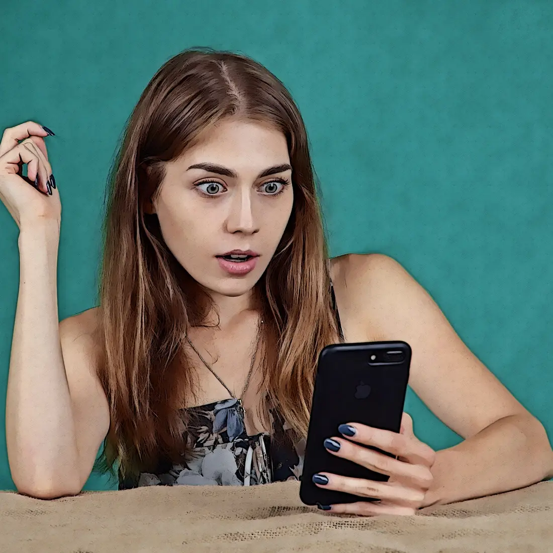 Woman looking at a cell phone with a surprised look