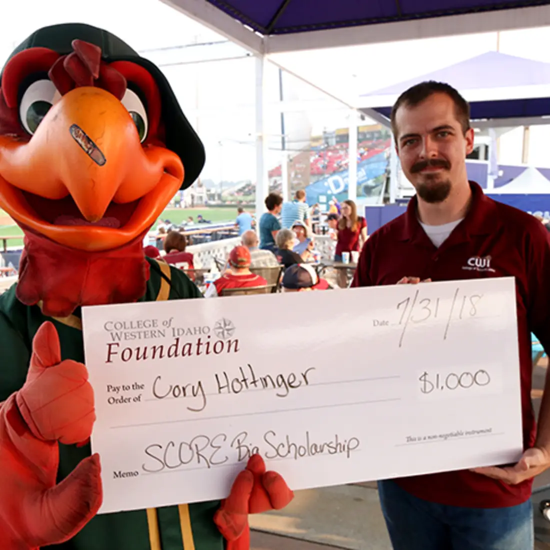 A #mightyCWI student receives a $1,000 scholarship during CWI Night at the Boise Hawks.