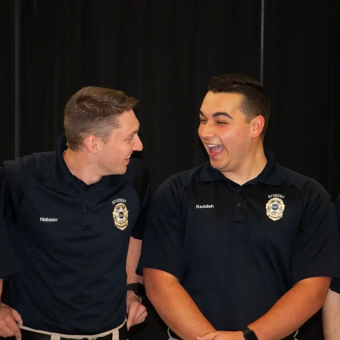 Rigdon Reddish laughing with fellow graduate at Law Enforcement Ceremony