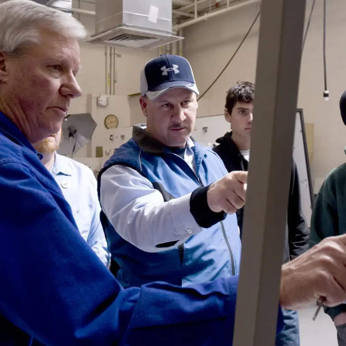 Instructor and students looking at plumbing equipment