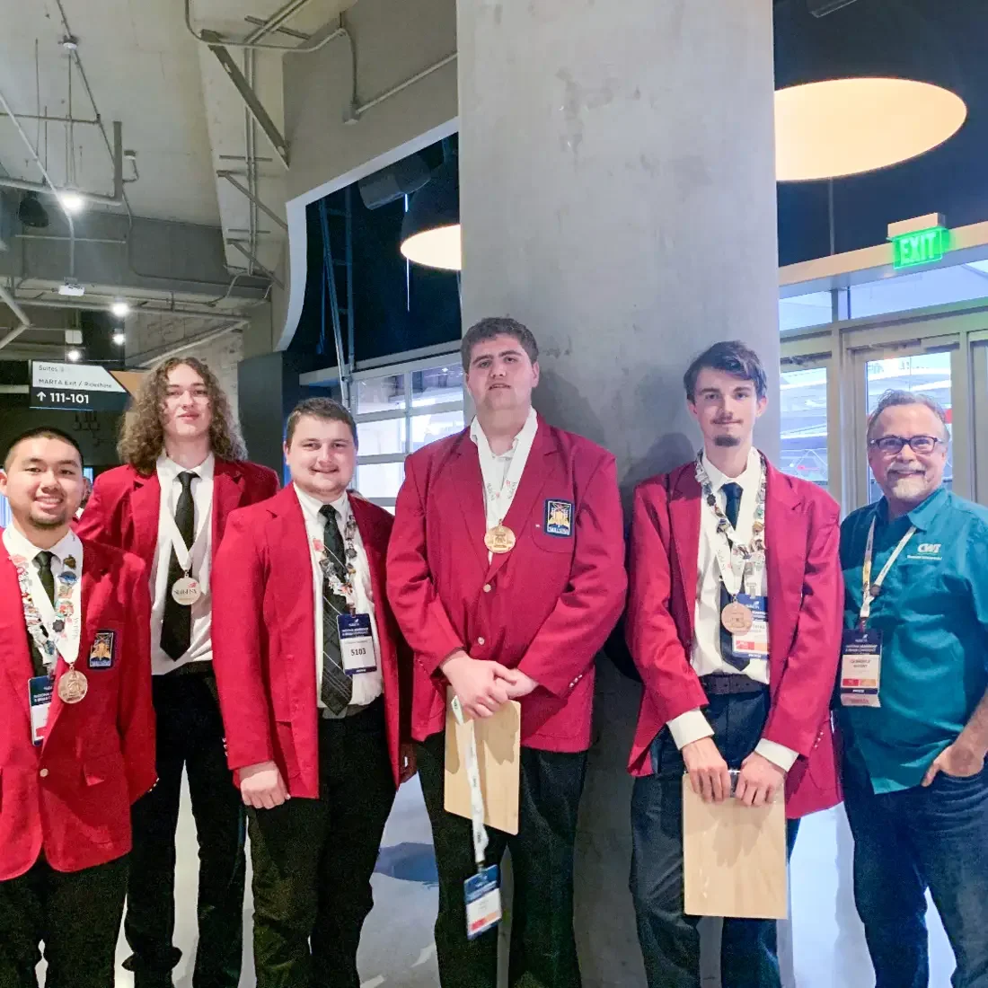 Students pose for a photo holding awards.