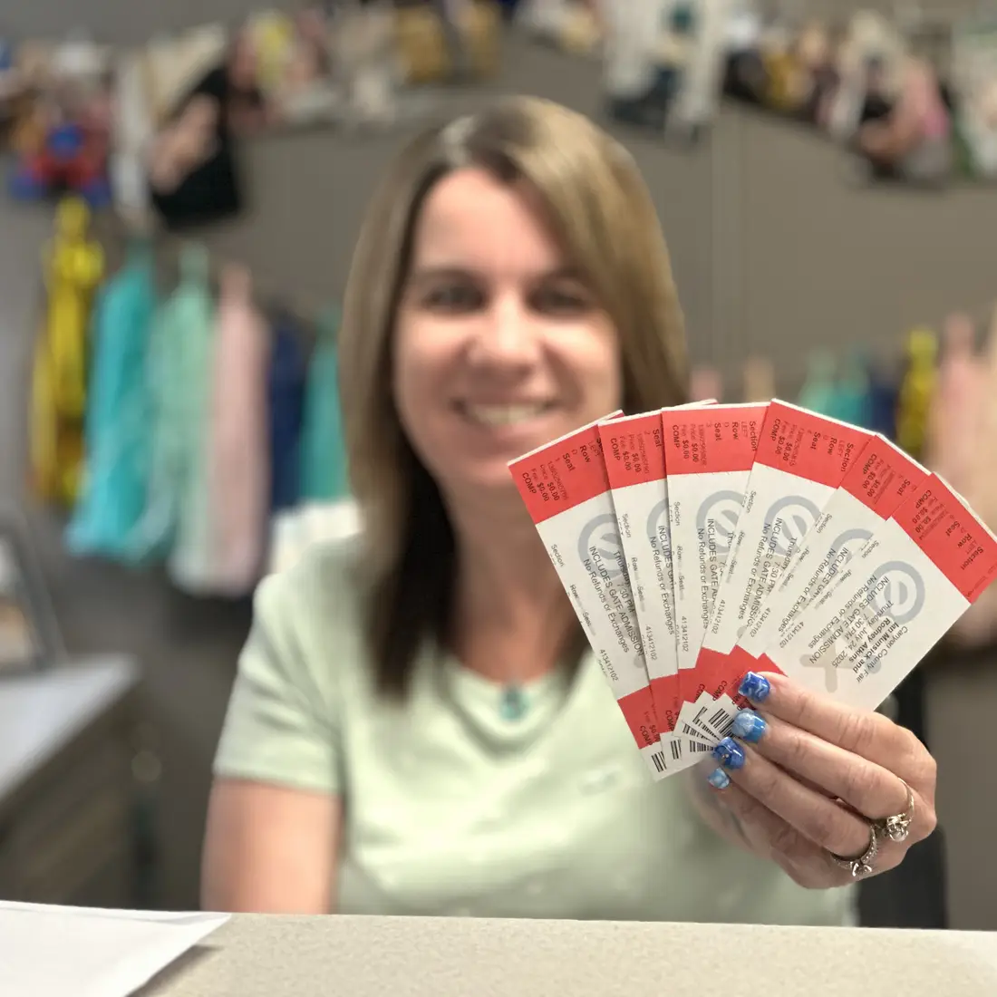 Employee holding fair concert tickets