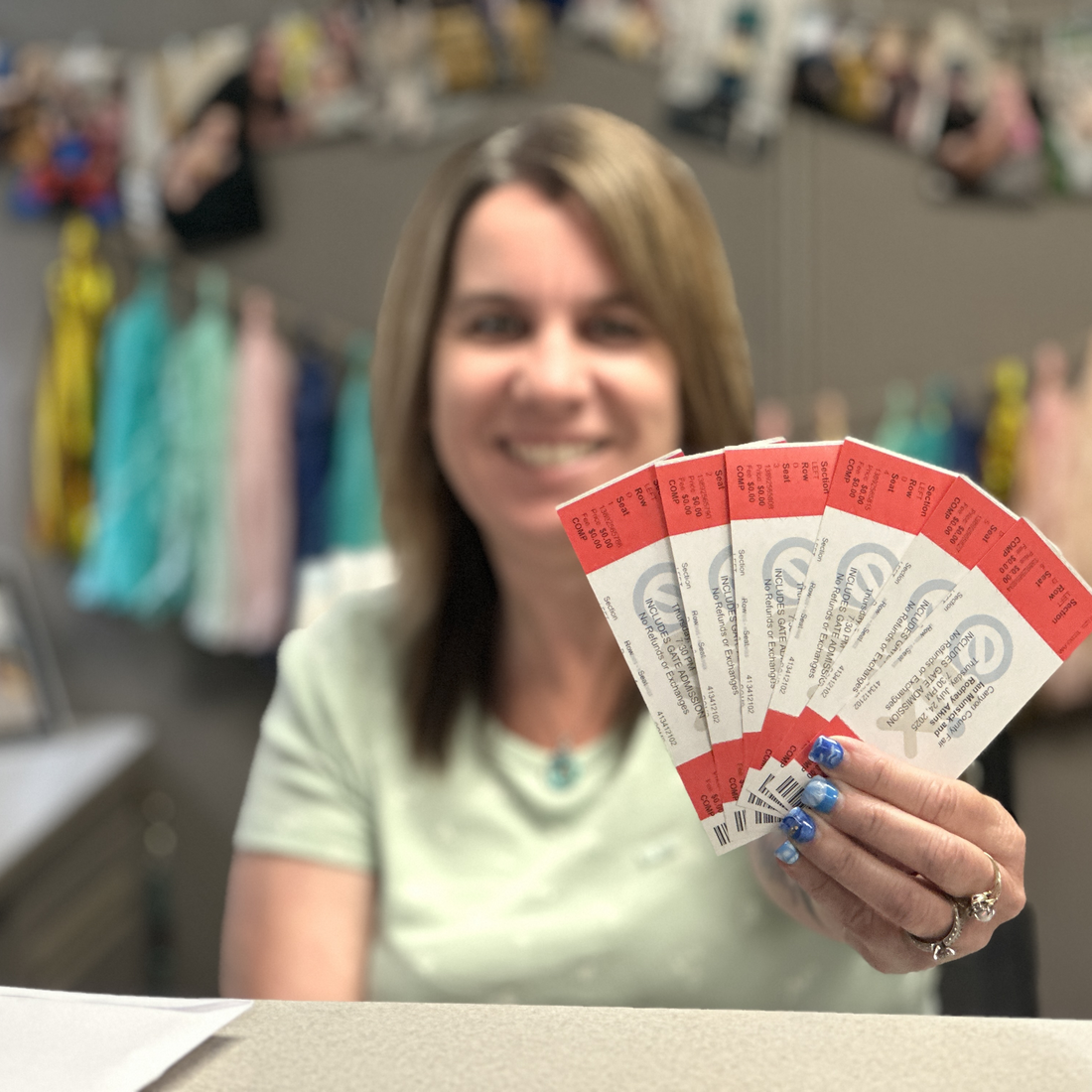 Employee holding fair concert tickets