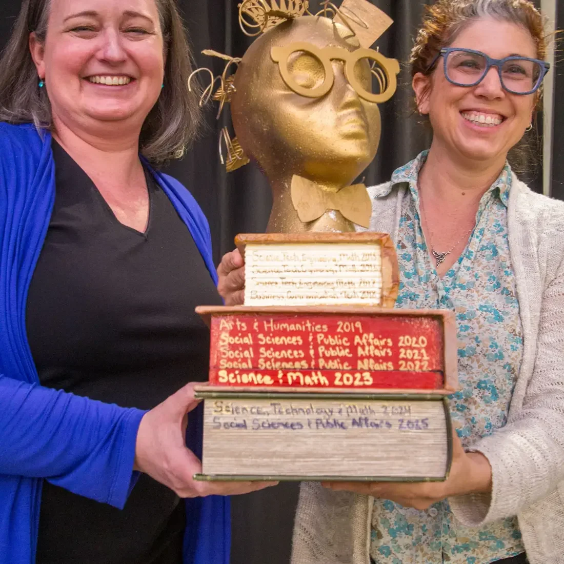 An academic trophy is awarded to a recipient. 