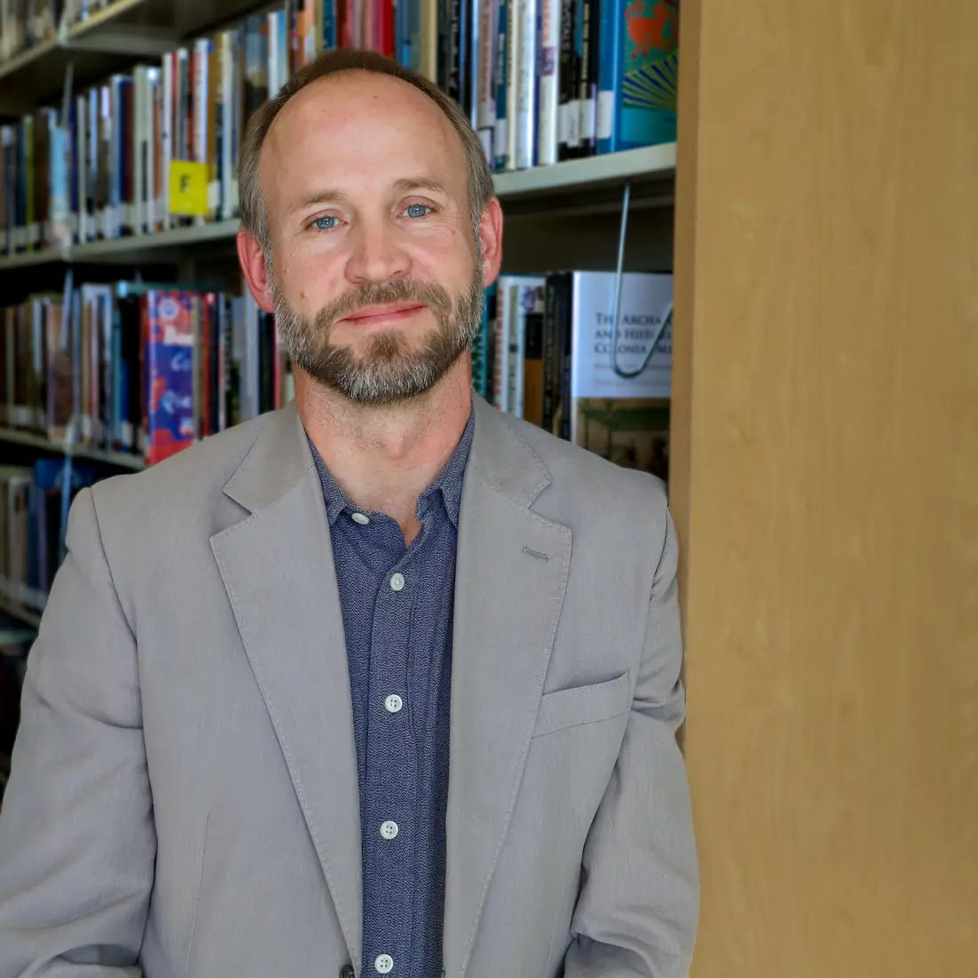 Jaren Watson leaning against bookshelf 