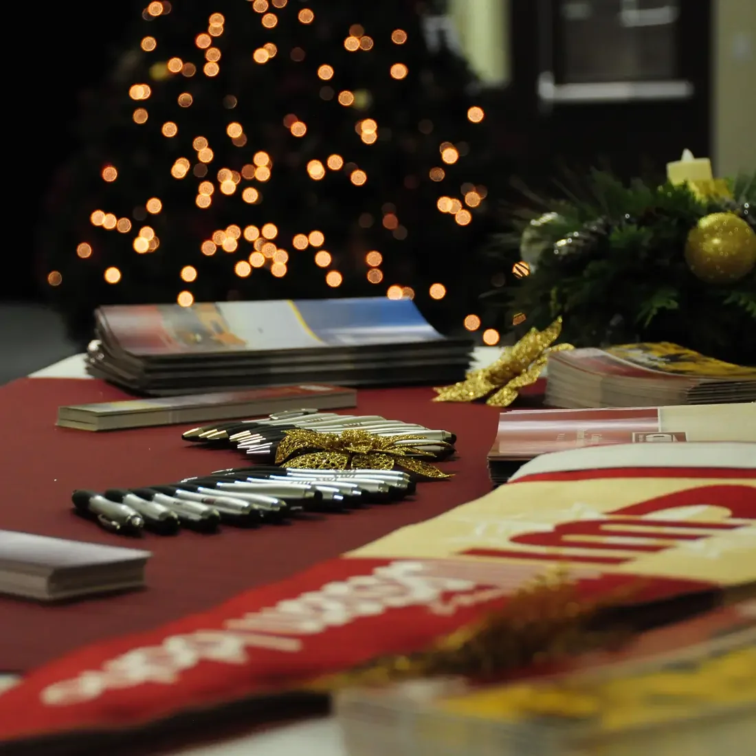 Table with CWI banner, pens, flyers and Christmas in background