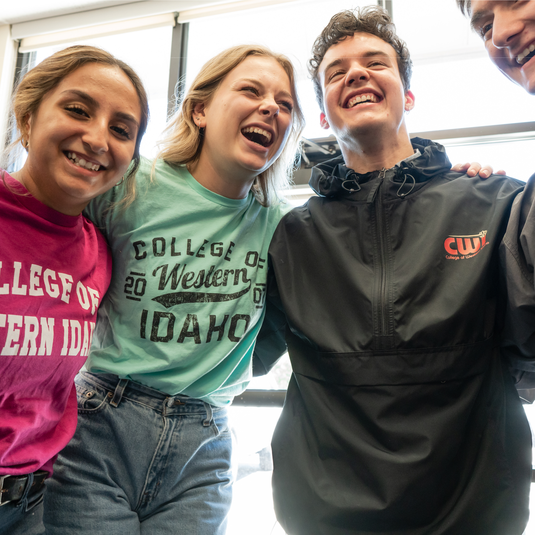 Students with arms around each other smiling and laughing