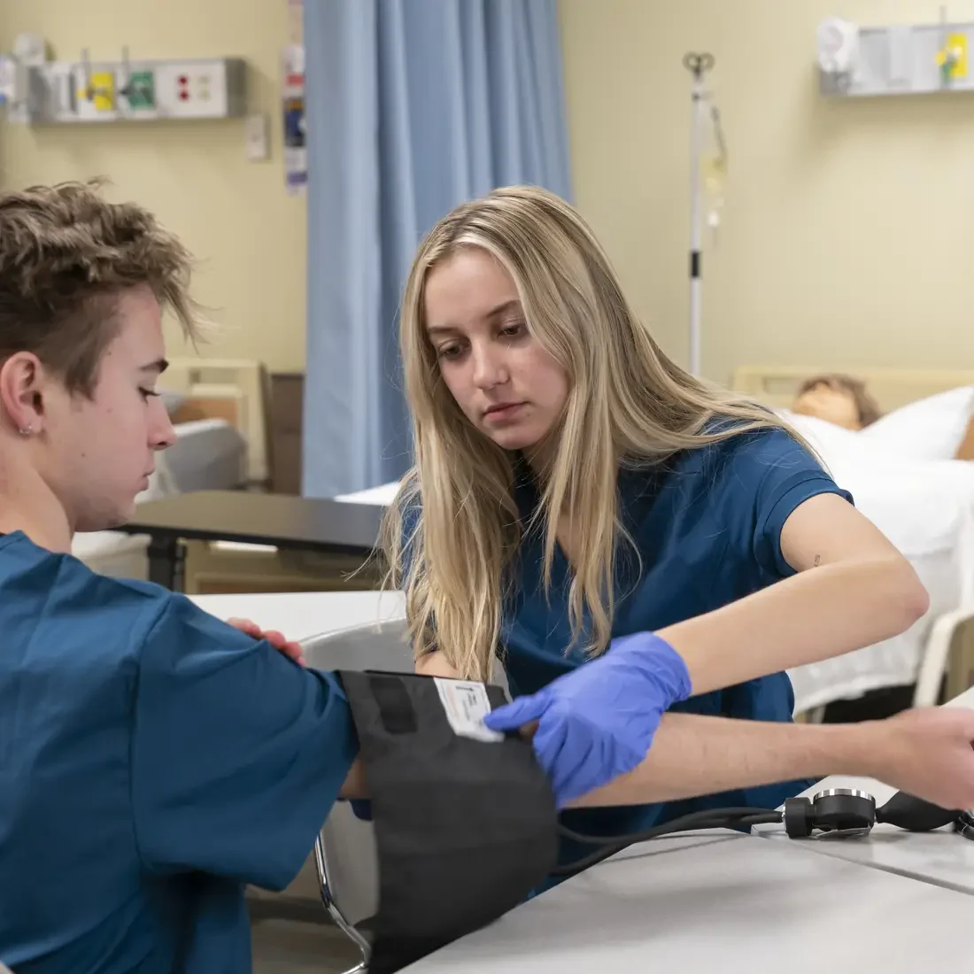Nursing student taking blood pressure of another student