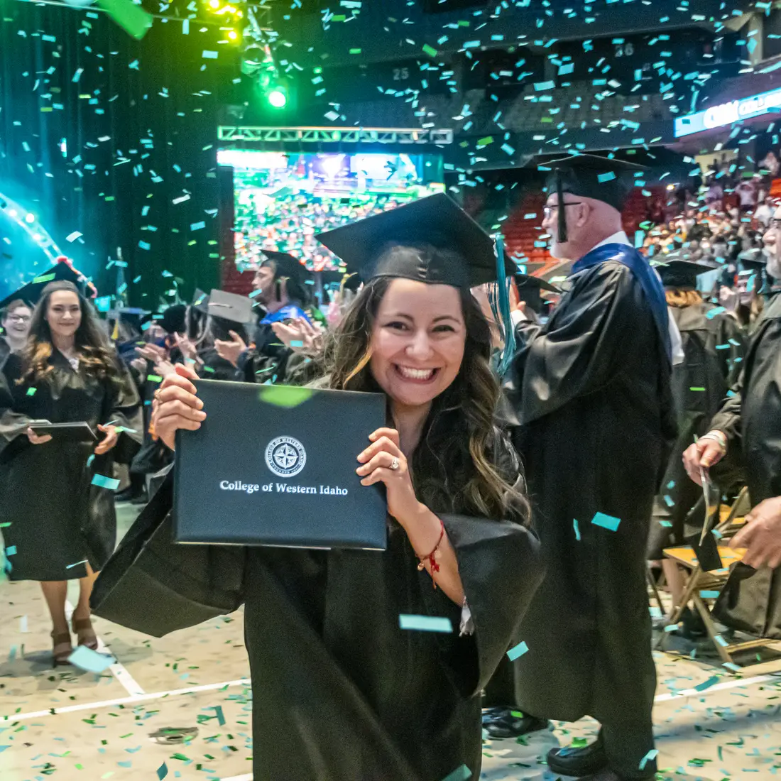 Graduate holding up degree