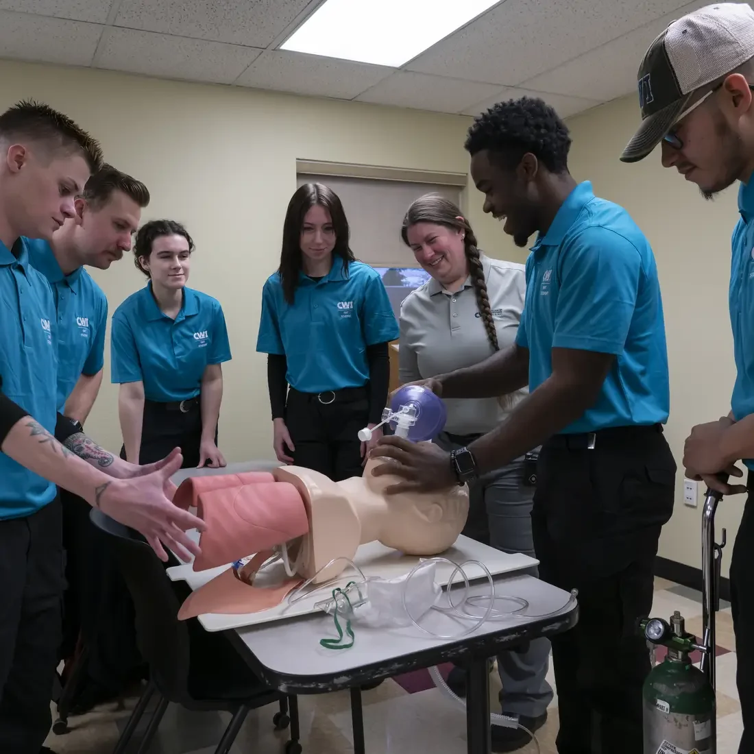 EMT students gathered mannequin practicing skills 