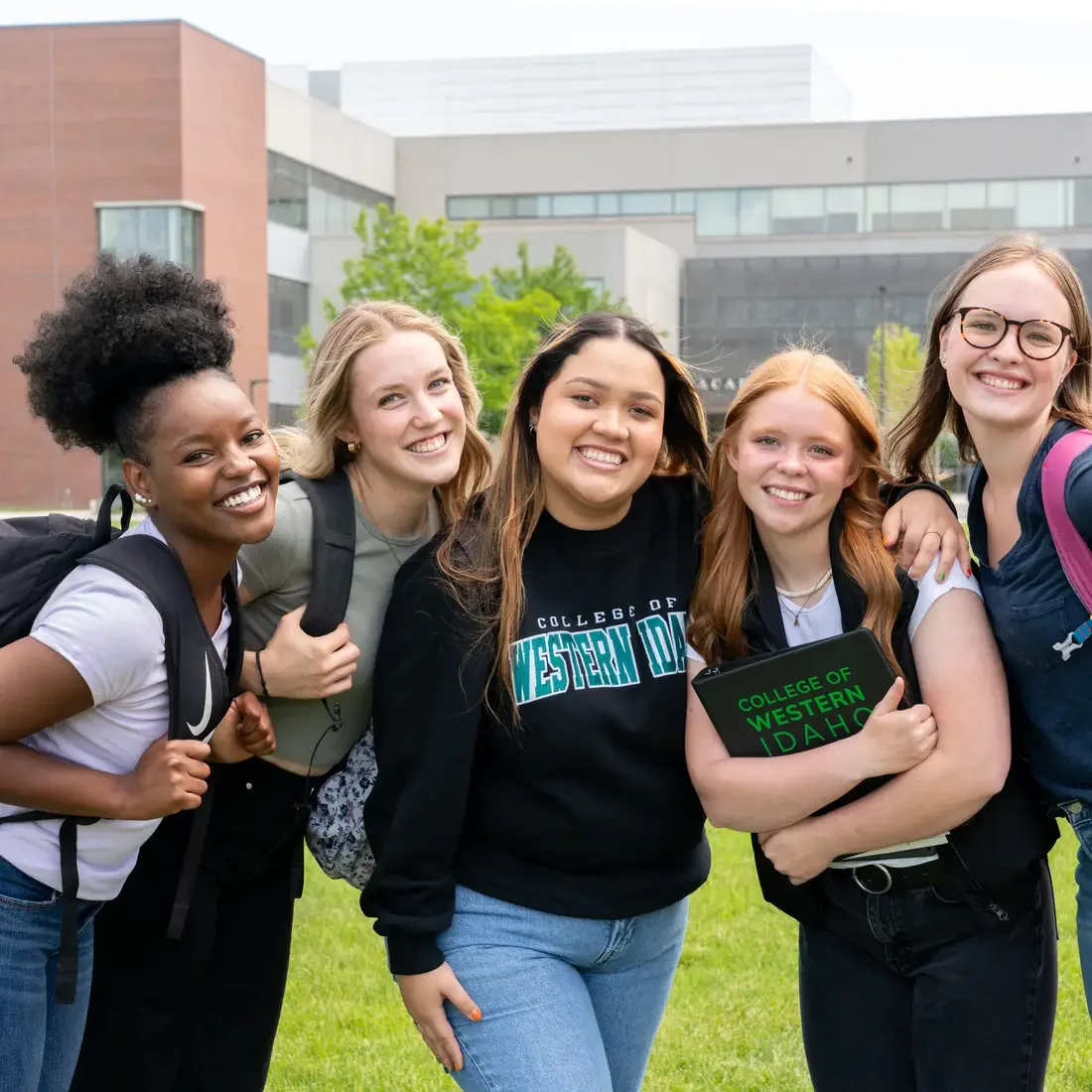 Group of students posing together outside a campus building
