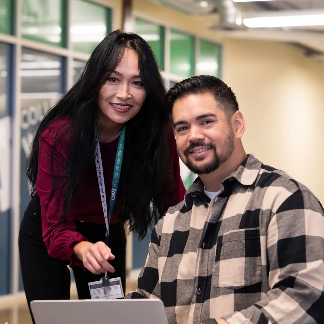 Student and Advisor in common area working over a laptop.
