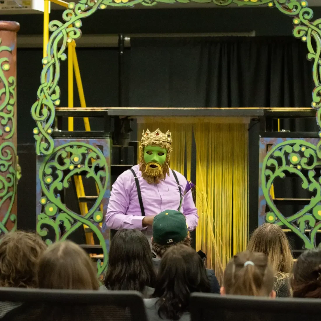 Actor on stage in makeup and crown
