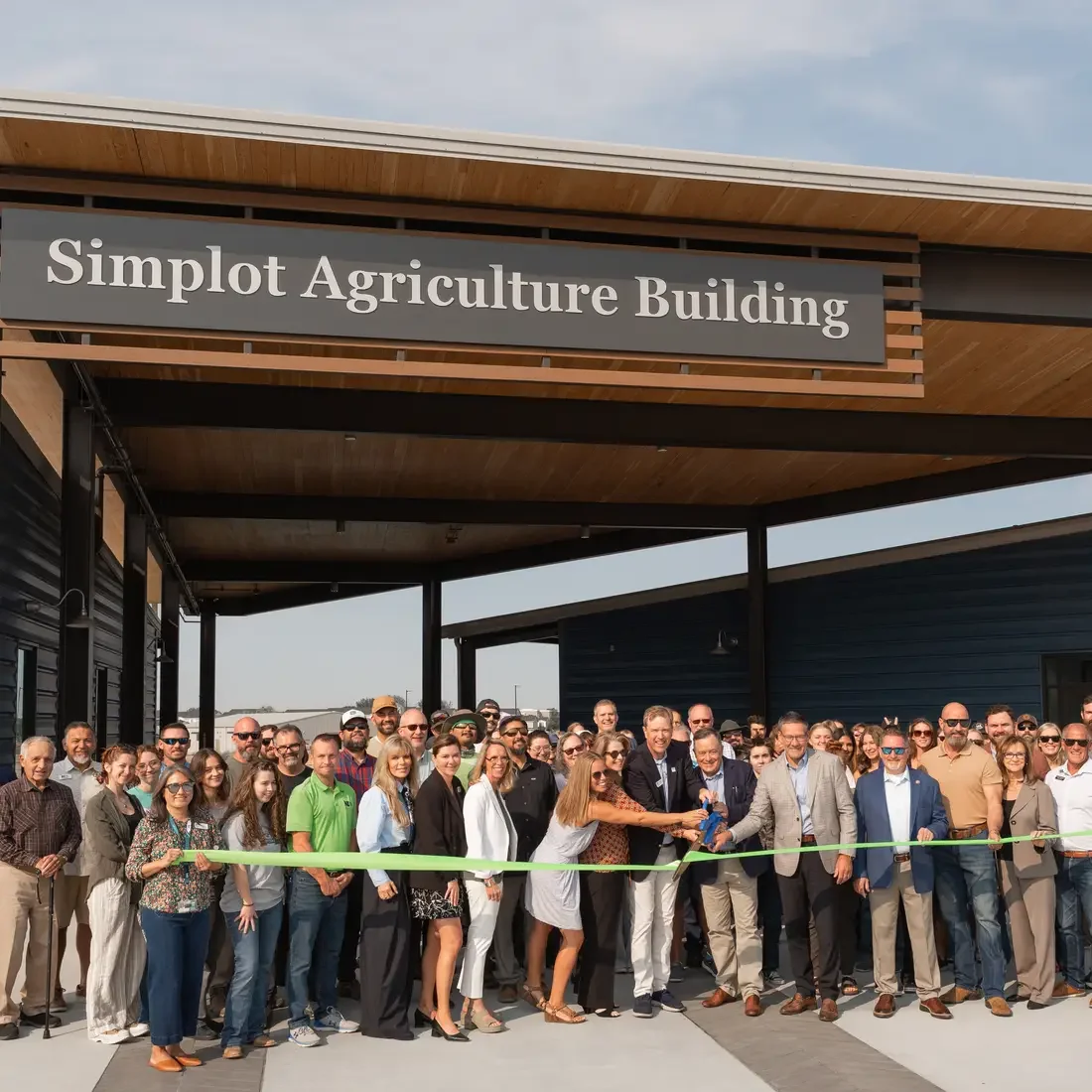 Large group gathered for a ribbon-cutting ceremony in front of the Simplot Agriculture Building at College of Western Idaho.