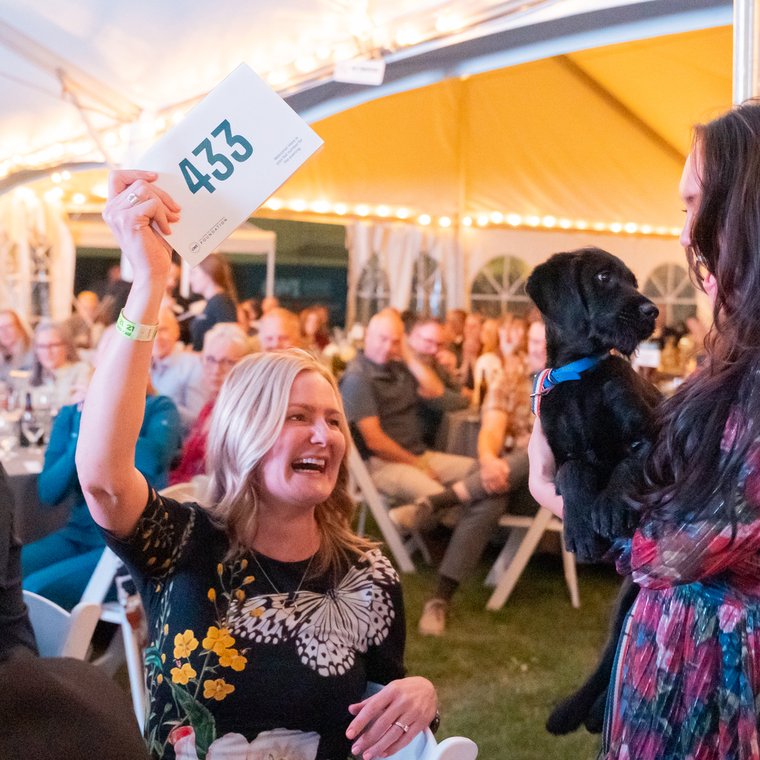 Woman holding up paddle to bid