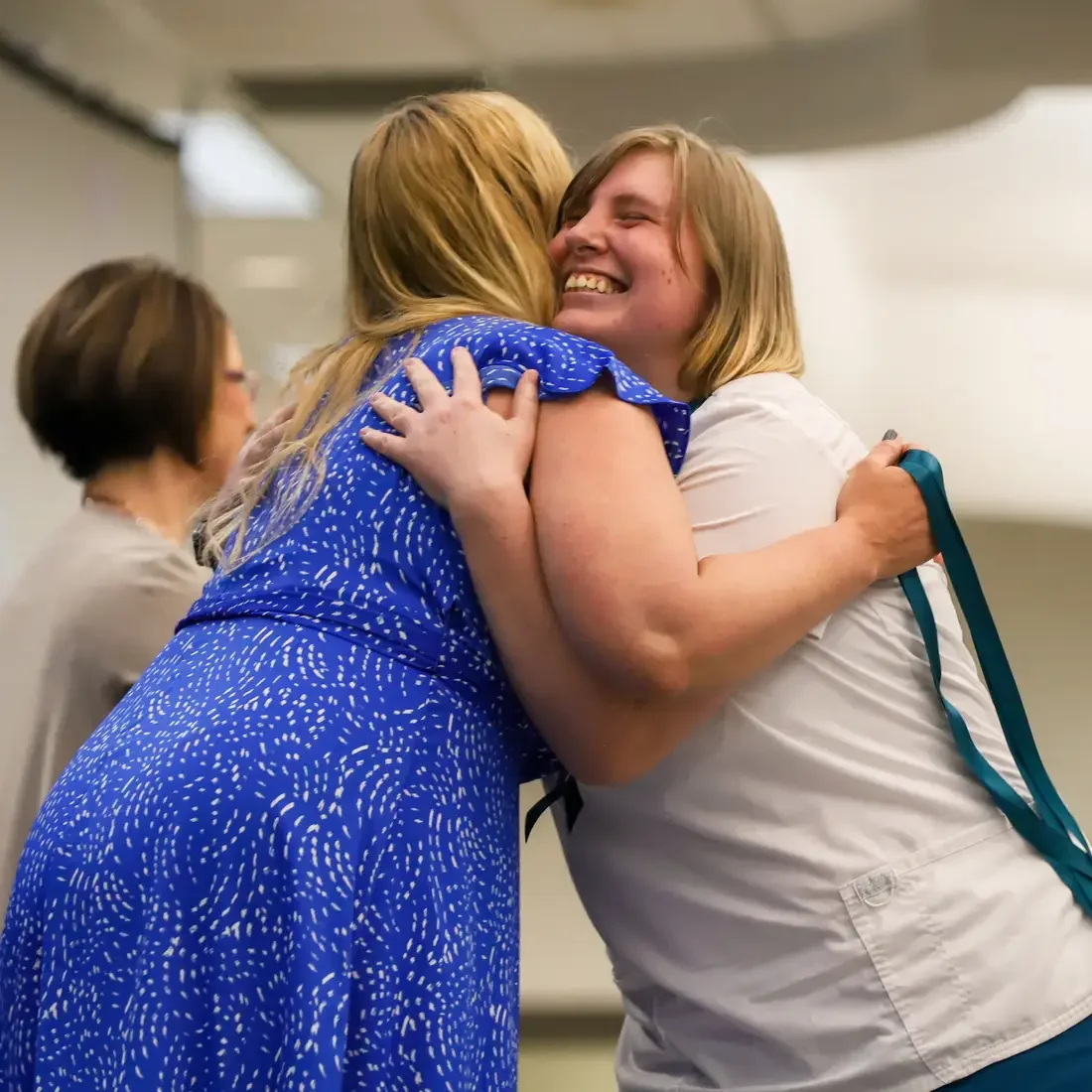 Graduate embracing faculty after being pinned