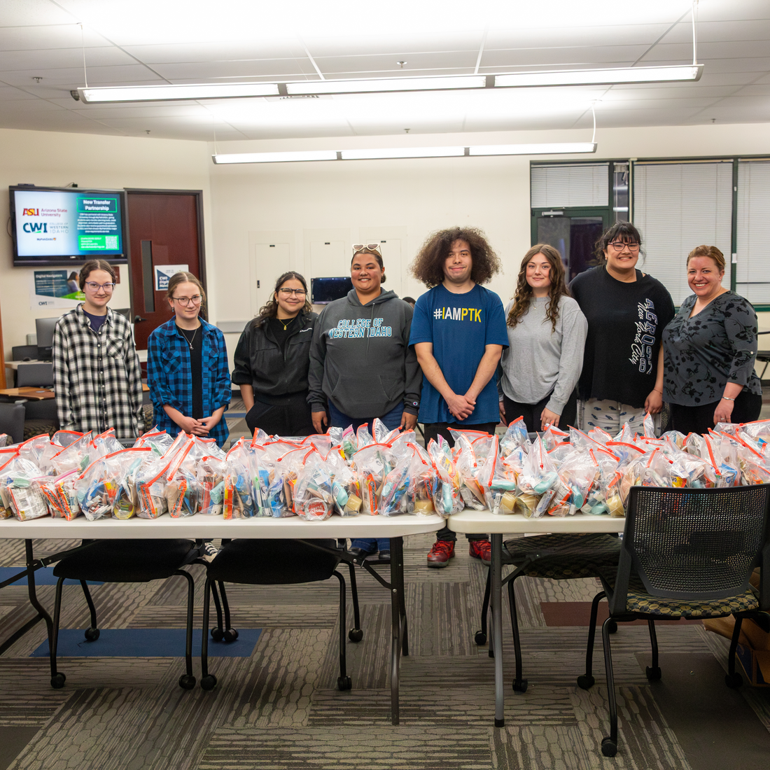 Students stand in front of food and hygiene bags