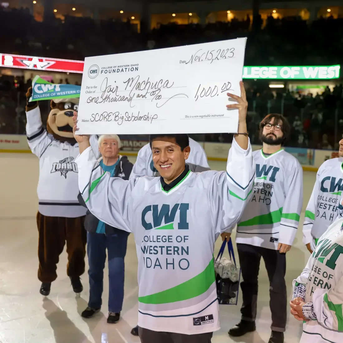 Jair Machuca holding up a check