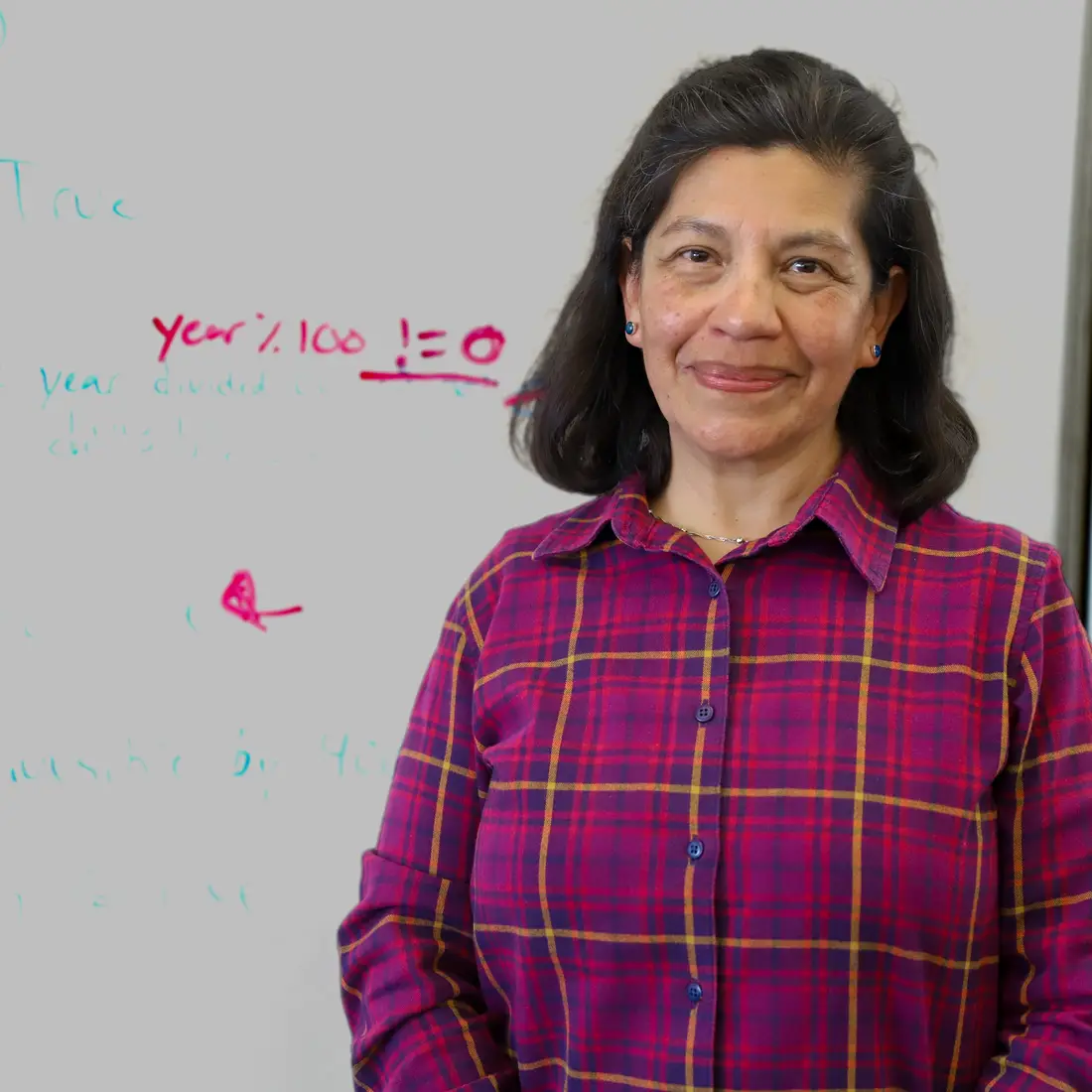 Teresa Tarifa de Yensen in front of a white board at the Tutoring Center