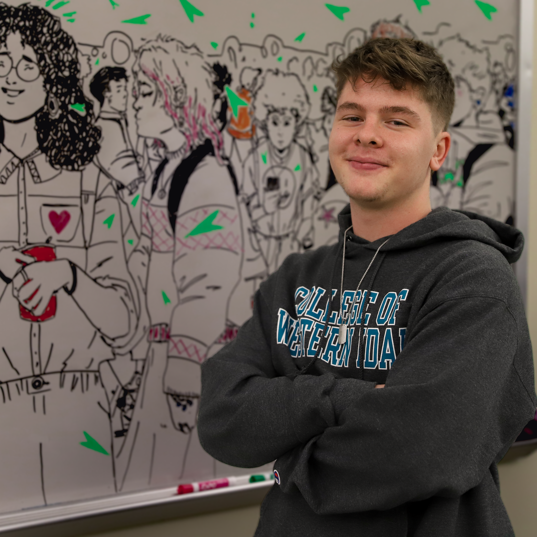 Caleb Chereji standing in front of his whiteboard mural