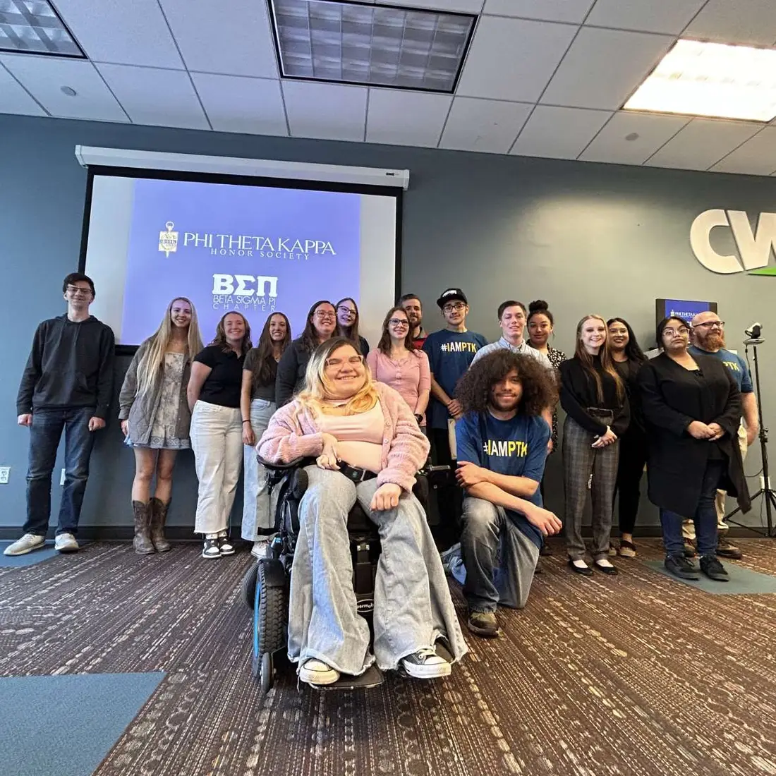 A group of students smile for a photo as they are inducted into an honors society.