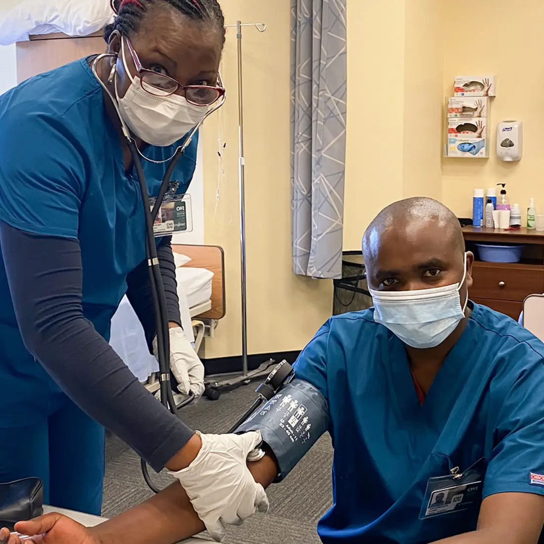 Multicultural Nursing Assistant students practicing taking blood pressure