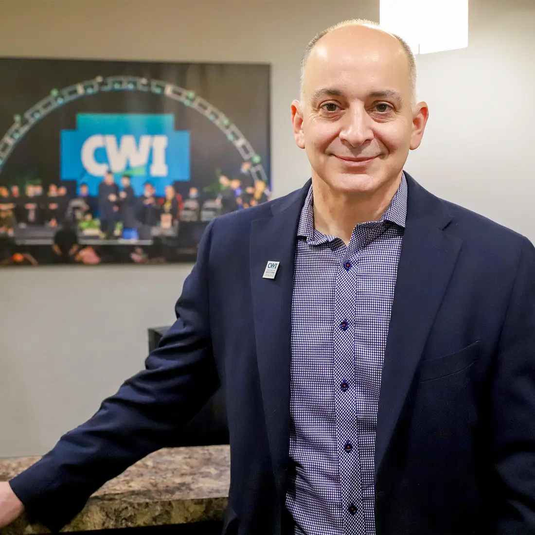 Kenneth Kline standing in front of desk and CWI picture