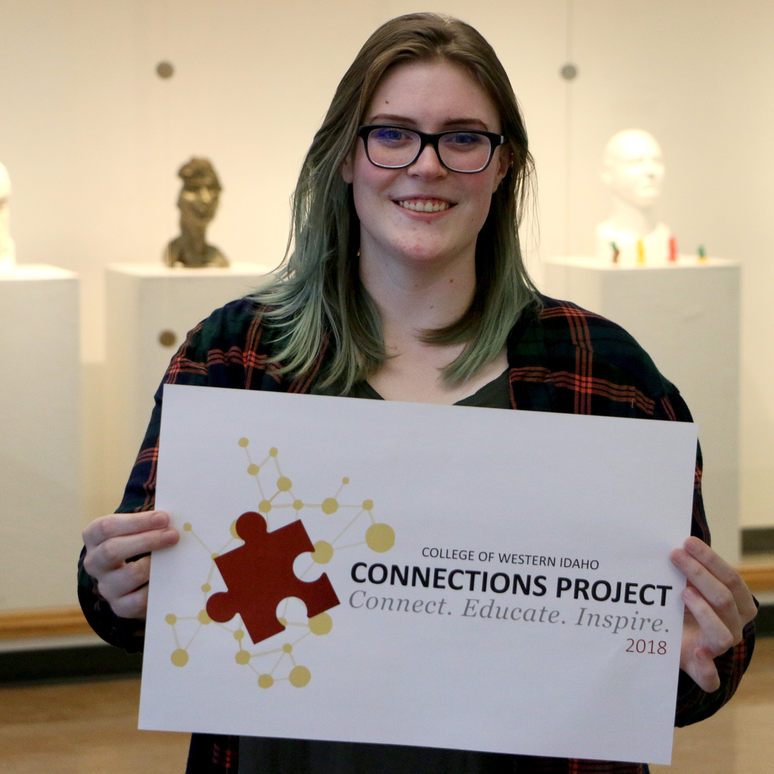 Obendorf holding a print of the 2018 Connections Project logo she designed.