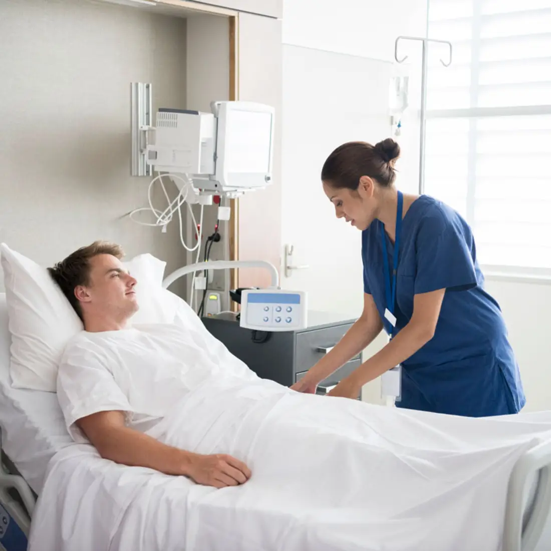 Nurse helping a patient in a hospital bed